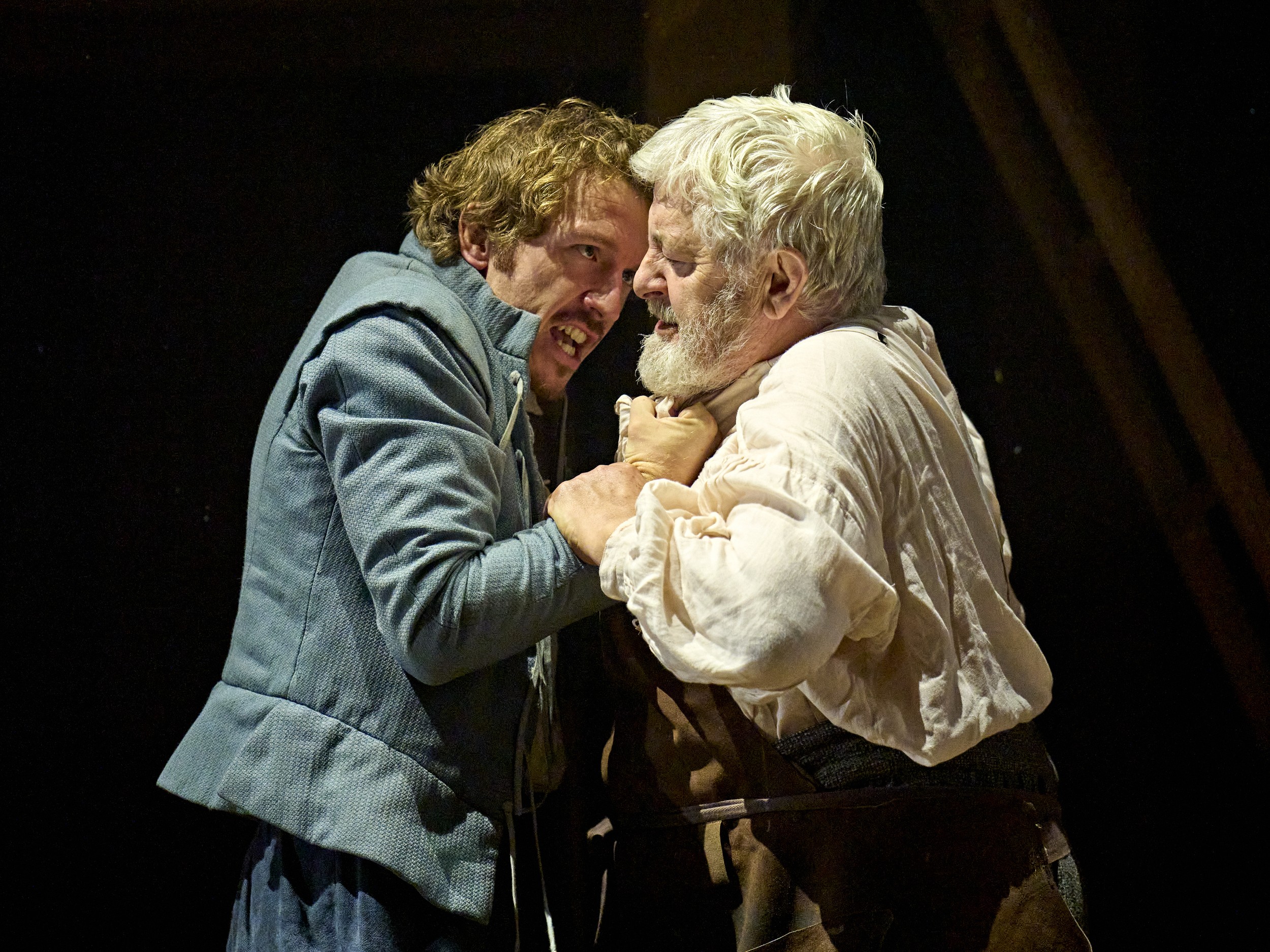London cast members of Hamnet pose together on stage, dressed in period costumes, with dramatic lighting.