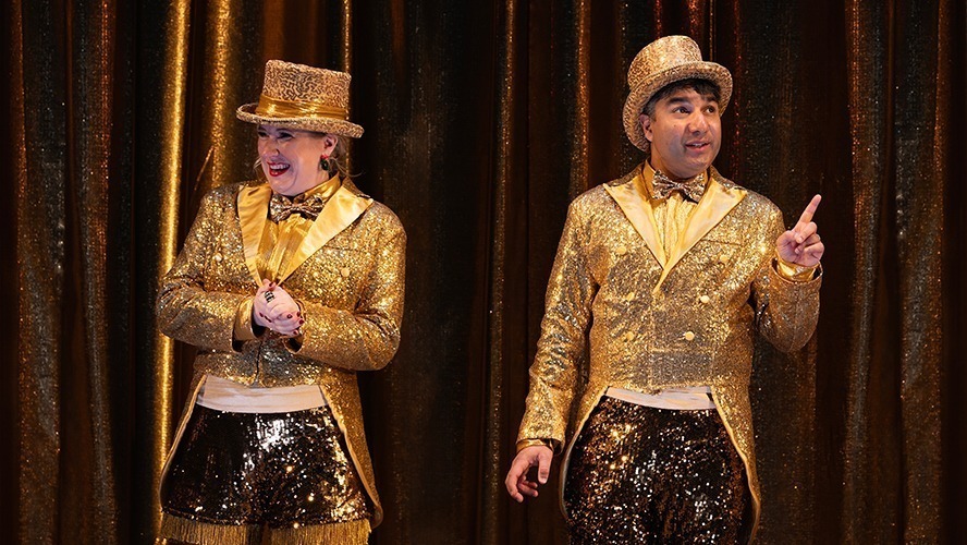 Matt Crockett performing in a festive scene from A Christmas Carol (ish), with theatrical lighting.