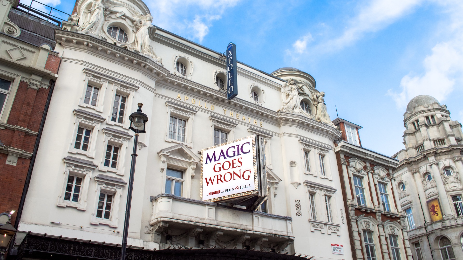 Exterior view of the Apollo Theatre, showcasing its illuminated marquee and classic architectural details.