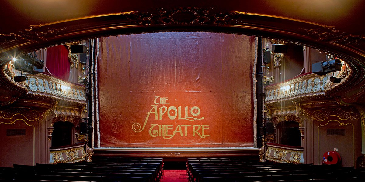 The Apollo Theatre exterior, featuring a marquee and vibrant signage against a twilight sky.