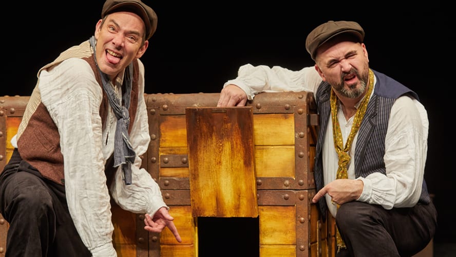 A vibrant stage scene featuring actors in historical costumes performing a lively theatrical production.