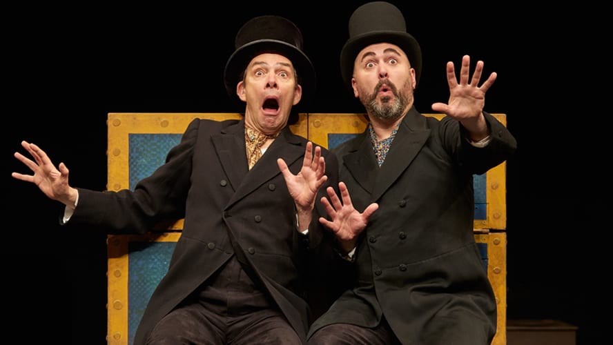 A vibrant stage scene featuring actors in historical costumes, engaging in a lively performance.
