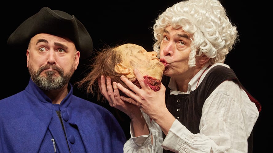 A vibrant stage scene featuring actors in historical costumes, performing energetically with props and set design.