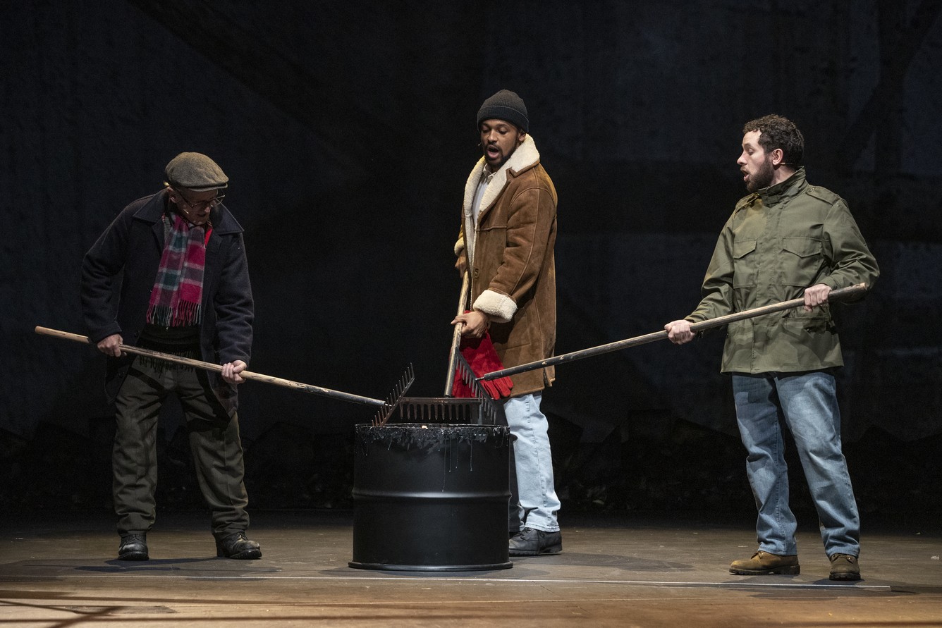Six actors in rehearsal, dressed in casual clothing, performing on stage at the Royal Court Theatre.