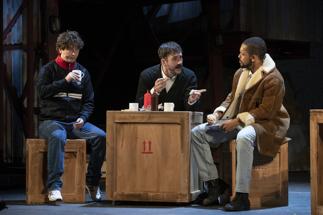 George Caple, Barry Sloane, and Aron Julius rehearsing on stage at the Royal Court Theatre.