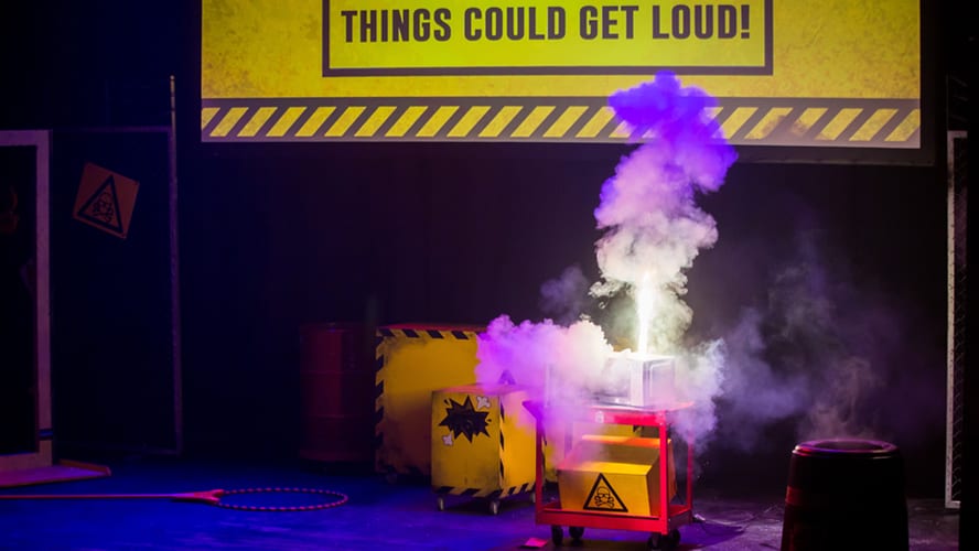 A vibrant stage set with colourful lights, featuring performers engaging with an enthusiastic audience.