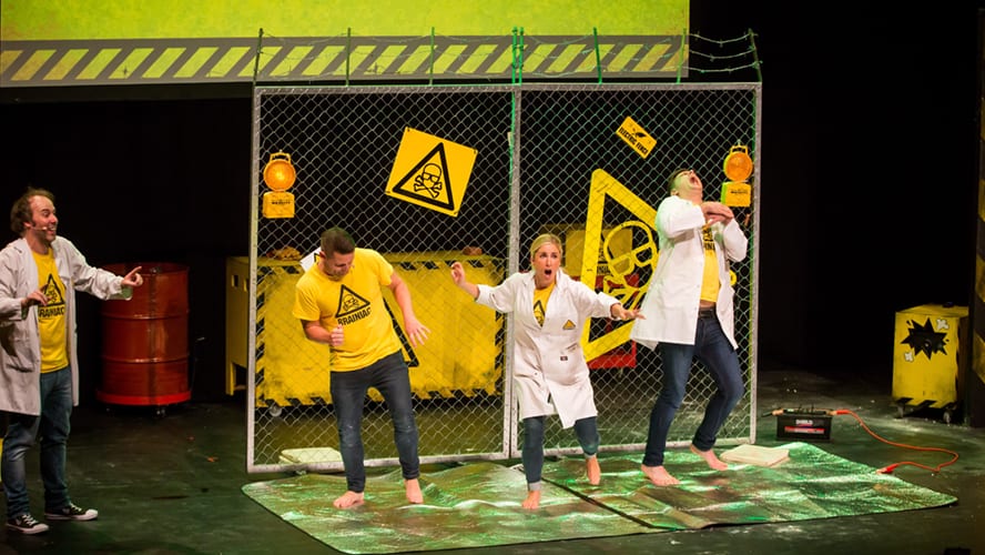 A vibrant stage set with colourful lights and props, showcasing a lively performance atmosphere.