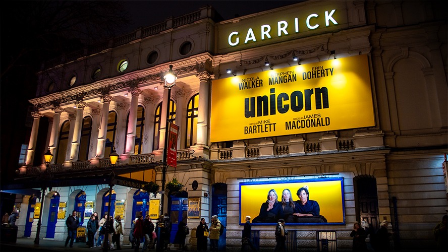 Garrick Theatre exterior featuring a classic façade and illuminated marquee at dusk.