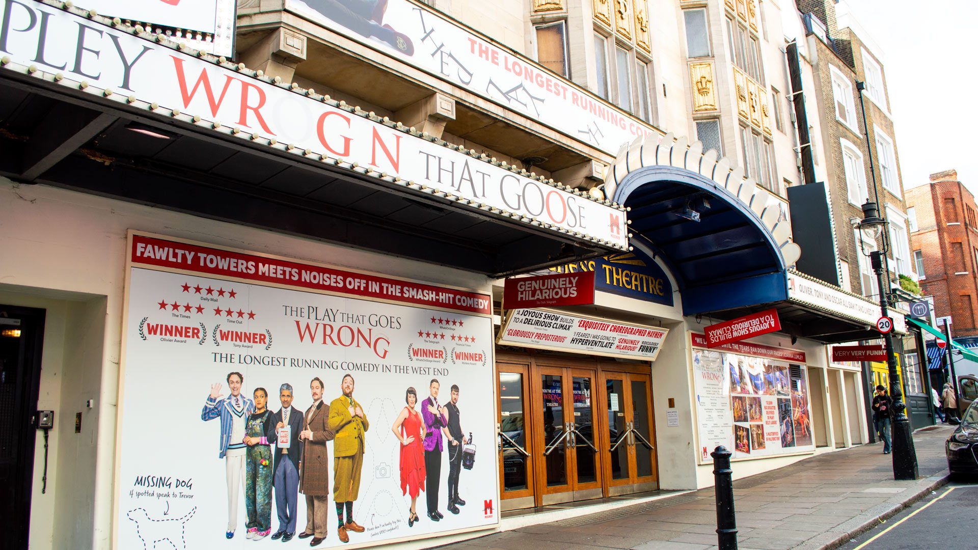 Duchess Theatre entrance featuring a vibrant poster for "The Play That Goes Wrong" and blue awning.