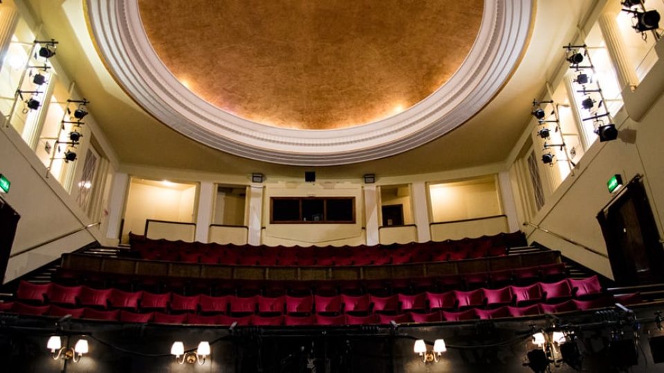 Duchess Theatre exterior featuring a classic marquee and ornate architectural details against a clear sky.