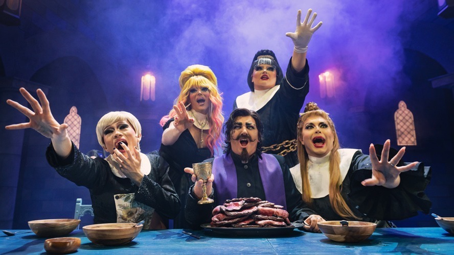 A theatrical scene featuring actors in vibrant costumes performing on stage at the Garrick Theatre.