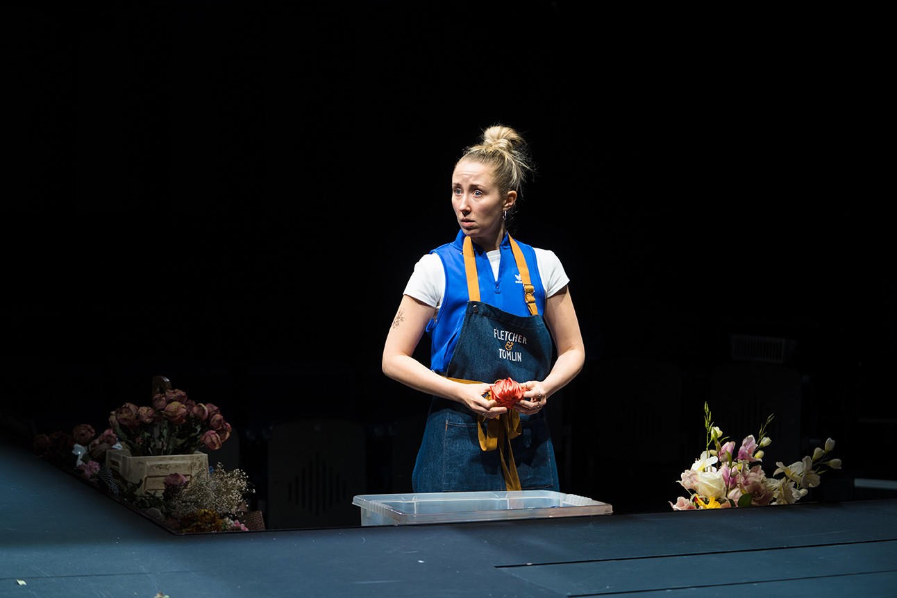A theatrical scene featuring actors on stage, with dramatic lighting and expressive poses.