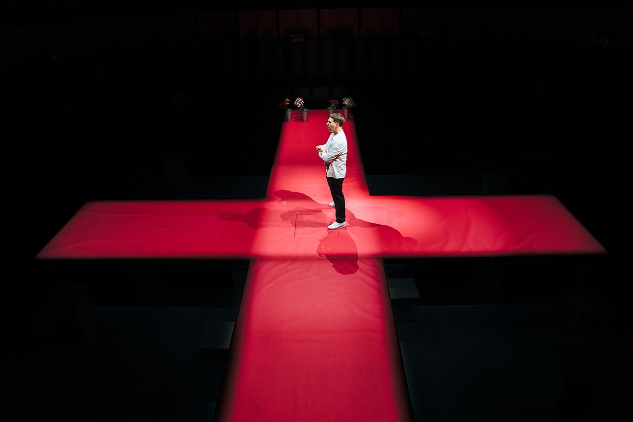 A theatrical scene featuring actors in dramatic costumes on stage, with focused lighting and expressive poses.