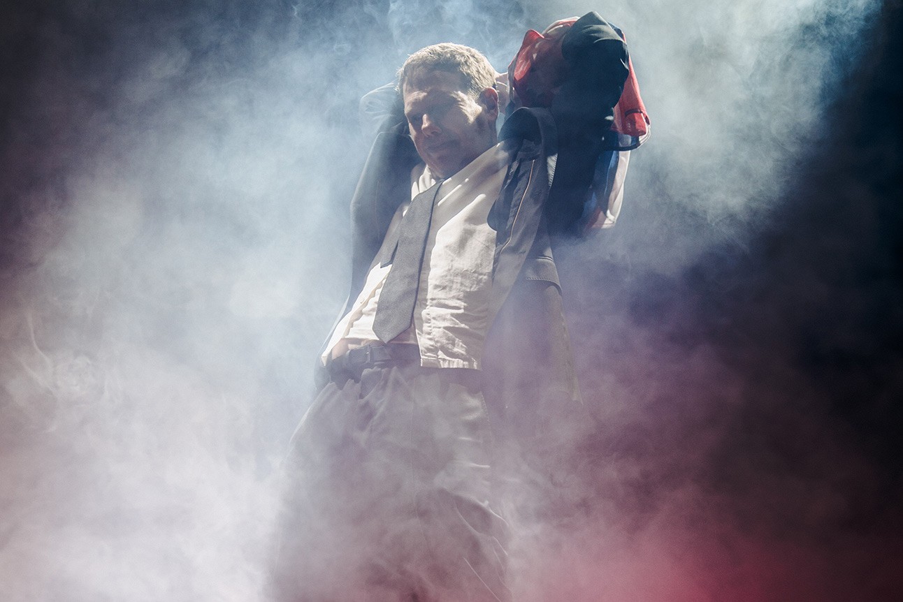 A theatrical performance scene featuring actors on stage, with dramatic lighting and expressive poses.