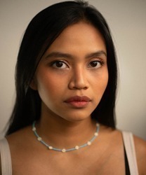 Desmonda stands elegantly, wearing a flowing gown, with soft lighting highlighting her features.