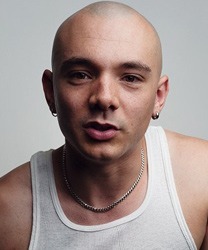 Dillon Scott Lewis, a man with short dark hair, smiles warmly at the camera.
