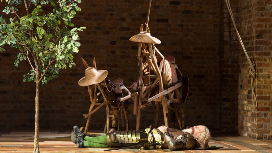 A scene from Don Quixote featuring a knight in armour on horseback against a dramatic backdrop.