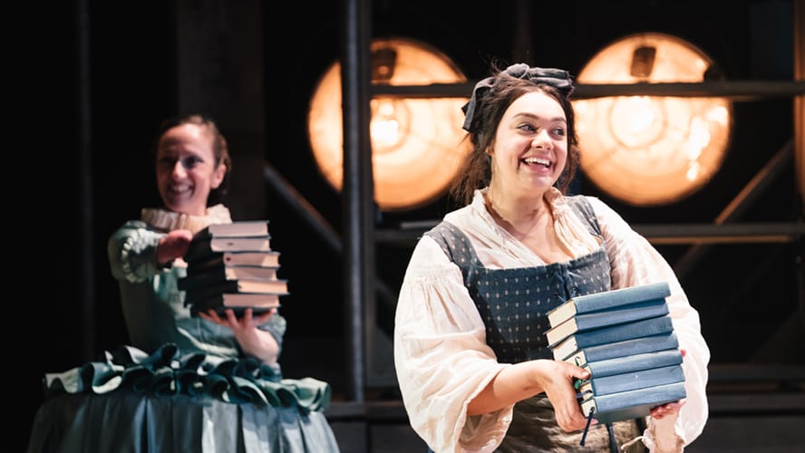 Actors performing on stage at the Vaudeville Theatre, with dramatic lighting and vibrant costumes.