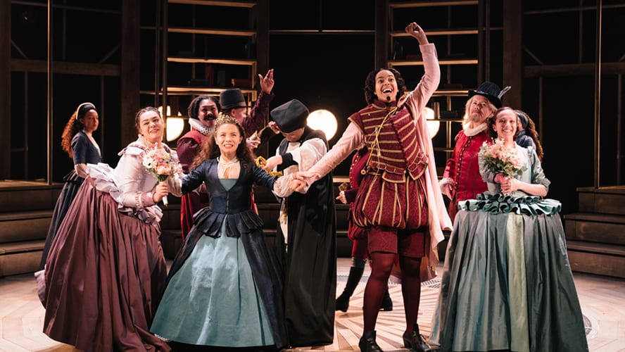 A vibrant stage scene from "Emilia" at the Vaudeville Theatre, featuring actors in period costumes.