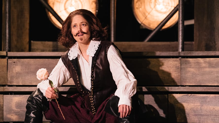 Actors performing on stage at the Vaudeville Theatre, with vibrant costumes and dramatic lighting.