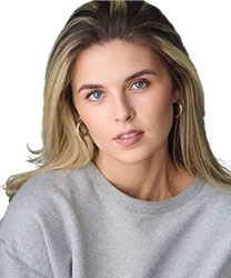 Erin Caldwell smiling, wearing a blue blouse, with shoulder-length brown hair and a neutral background.