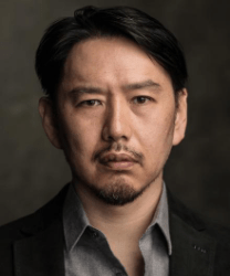 Eu Jin Hwang smiling, wearing a dark blazer and white shirt, with short black hair.