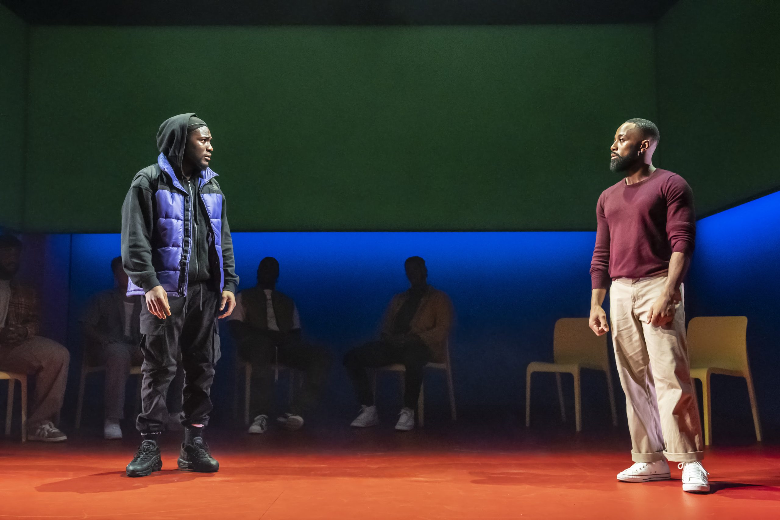 A stage scene from "For Black Boys Who Have Considered Suicide," featuring dramatic lighting and performers.