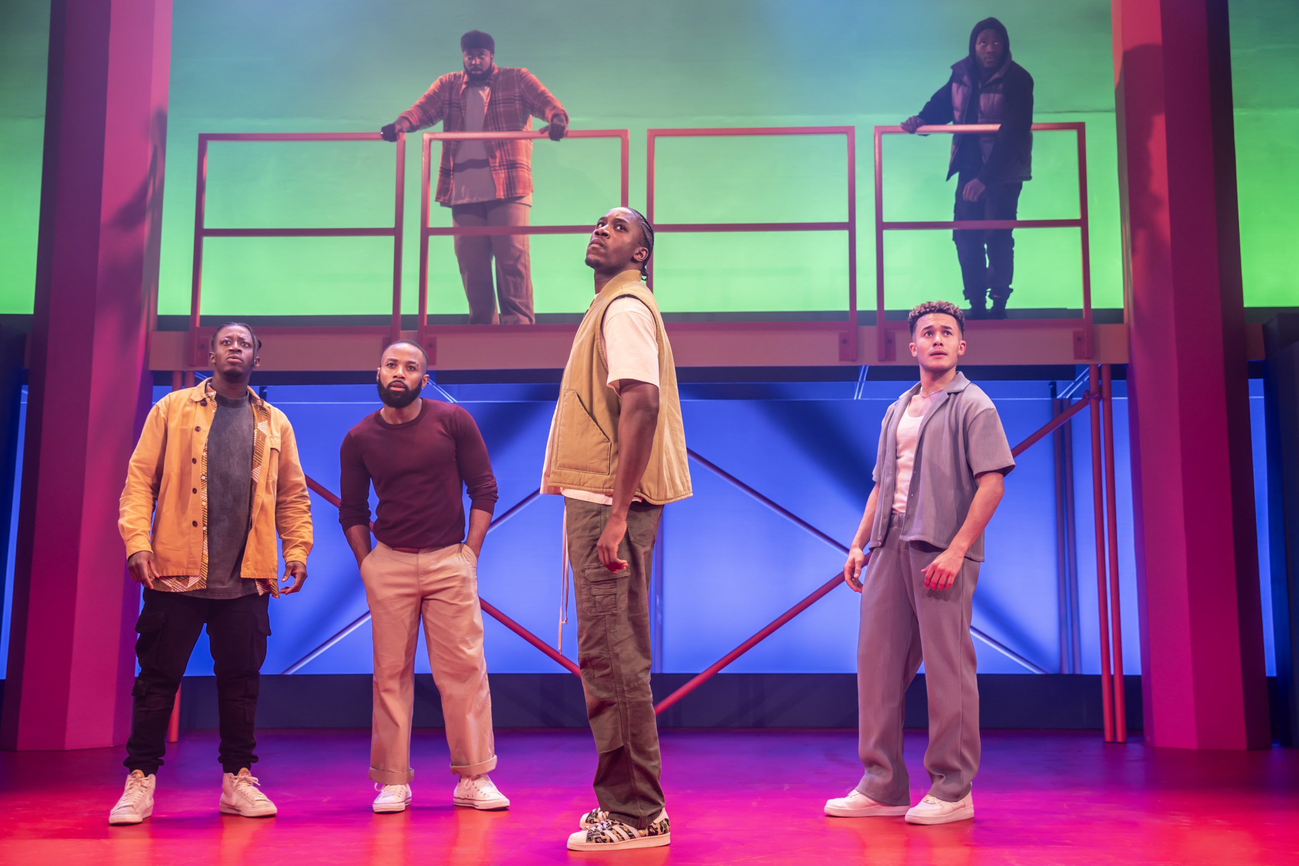 A theatrical performance scene featuring actors on stage with dramatic lighting at the Apollo Theatre, London.