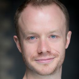 Gareth Cassidy, a man with short dark hair, wearing a navy suit and tie, smiling.
