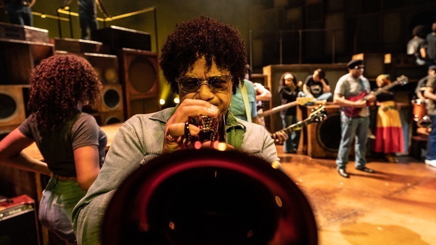 A vibrant stage scene from "Get Up, Stand Up" at the Lyric Theatre, featuring actors performing.
