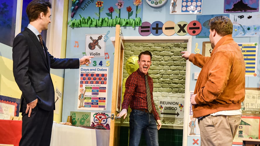 A lively stage performance at the Groan Ups Vaudeville Theatre with actors in vibrant costumes.