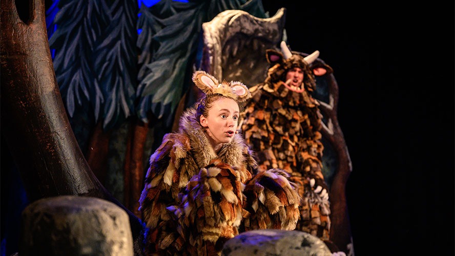 Harriet Waters in the foreground, with a whimsical forest background inspired by "The Gruffalo's Child.