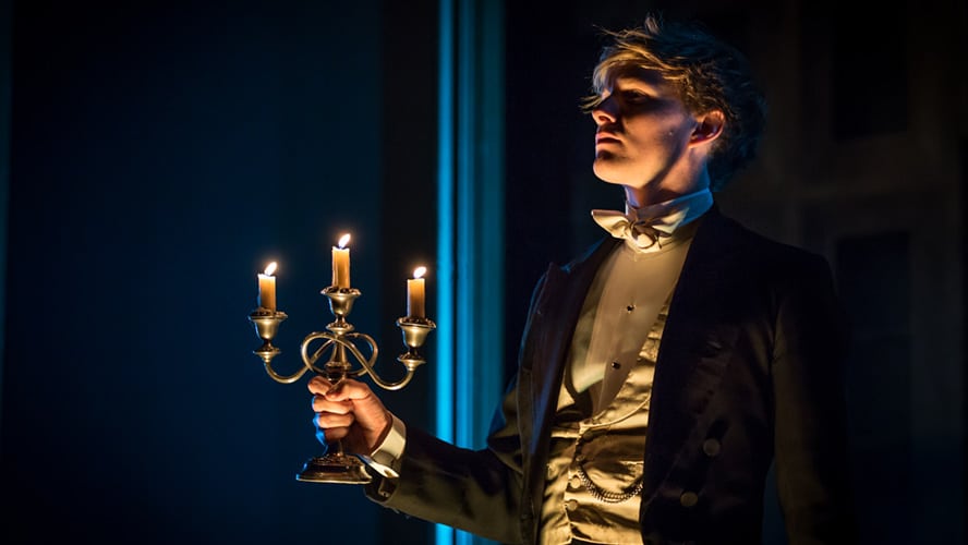 Harry Lister-Smith as Gerald Arbuthnot, dressed in period costume, standing on stage.