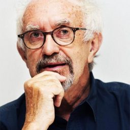 Headshot of a person with short dark hair and a neutral expression against a plain background.
