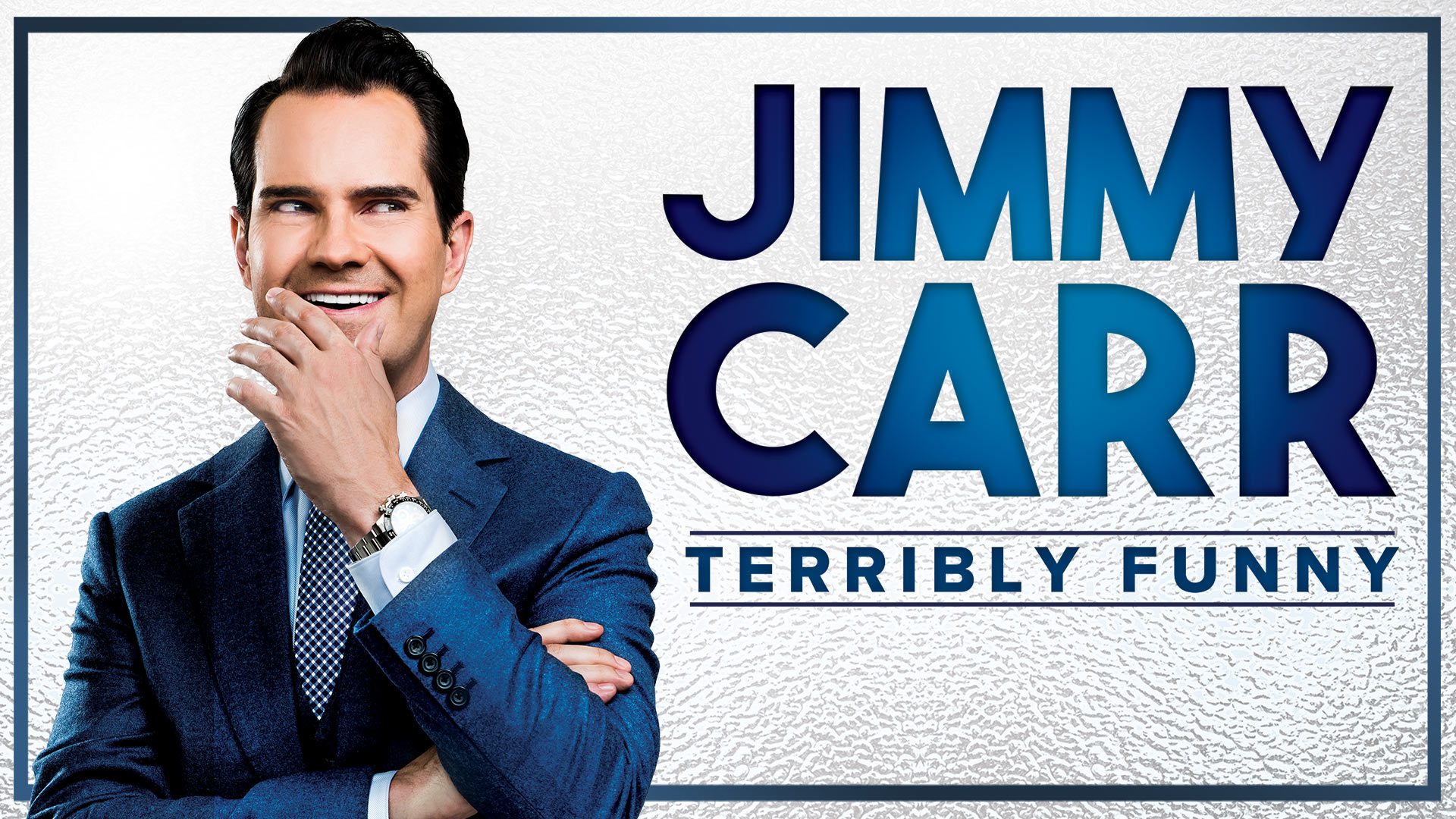 Jimmy Carr performing on stage, smiling, with a microphone in hand and bright stage lights.