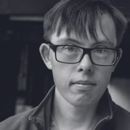 Headshot of Joe Sproulle, featuring a friendly smile and short dark hair against a neutral background.