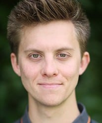Joey Hickman, a man with short brown hair, smiling against a neutral background.