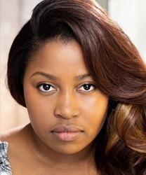 Karen Mavundukure smiling, wearing a blue blouse, with shoulder-length dark hair and a neutral background.