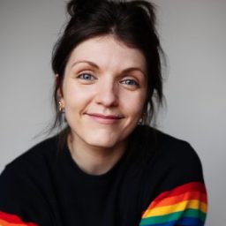Kate Donnachie, a woman with short brown hair, smiling against a neutral background.
