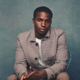 Kedar Williams-Stirling smiling, with short dark hair and a clean-shaven face, against a neutral background.