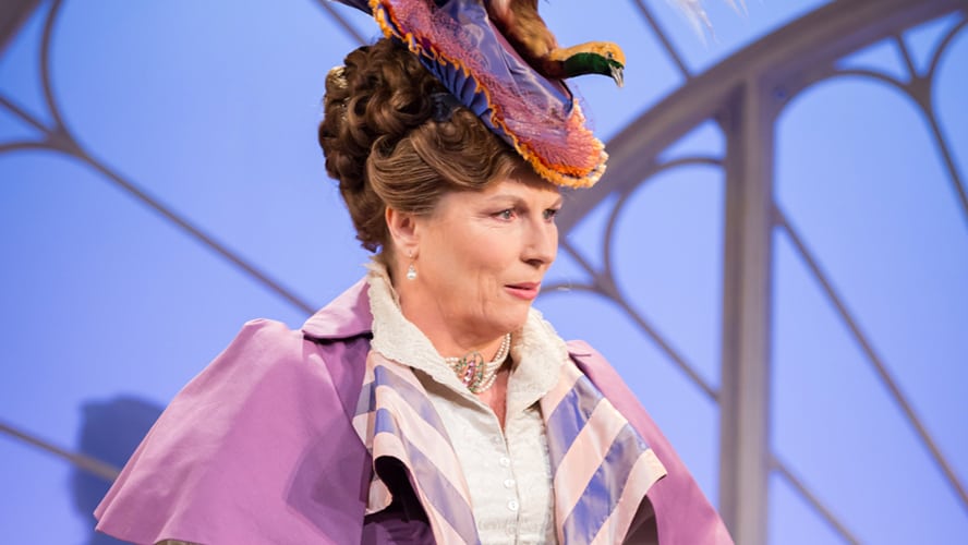 A scene from "Lady Windermere's Fan" featuring elegantly dressed characters in a lavish interior setting.