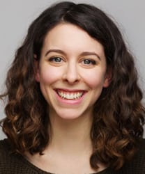 Lauren Silver smiling, wearing a navy blazer and white blouse, with shoulder-length brown hair.