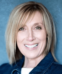 Linda Jarvis smiling, wearing a navy blazer, with shoulder-length brown hair and a light background.