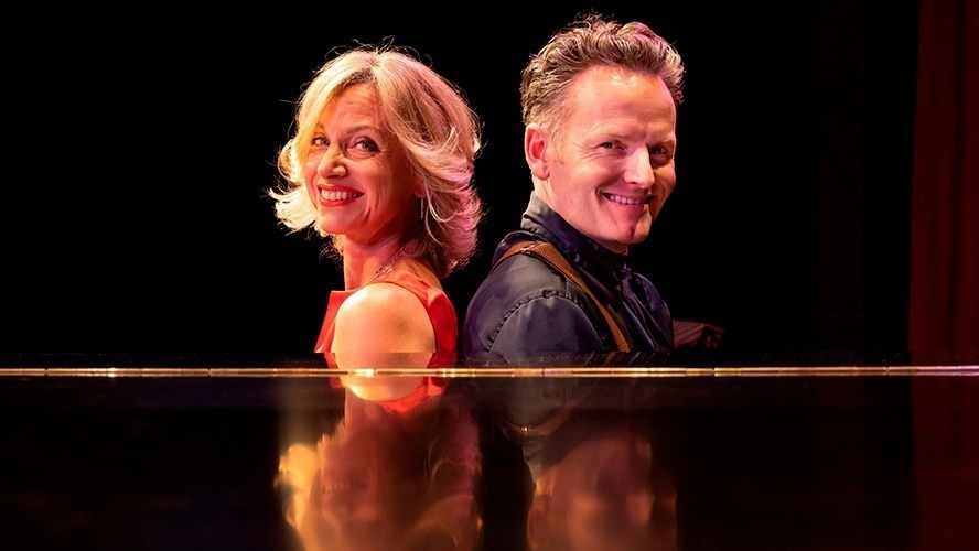 Liza Pulman and Jow Stilgoe smiling together at an event, dressed in smart casual attire.