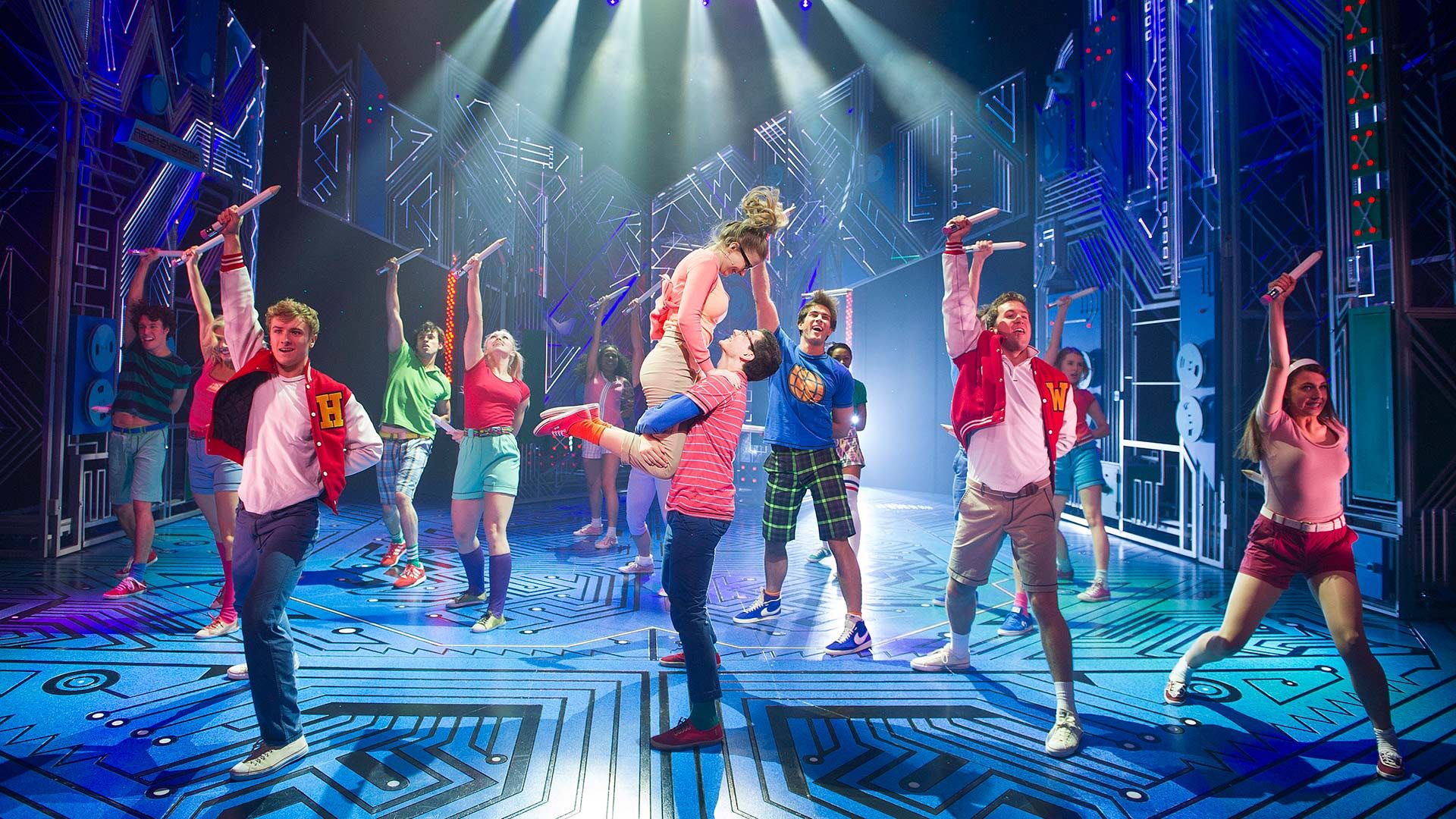 A lively concert scene featuring performers on stage with bright lights and an engaged audience.