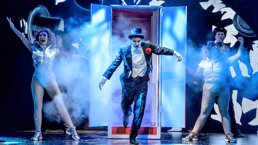 A stage at the Vaudeville Theatre, featuring dramatic lighting and props for a magic performance.