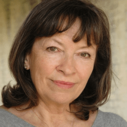 Marion Bailey with a neutral expression, wearing a dark top against a plain background.