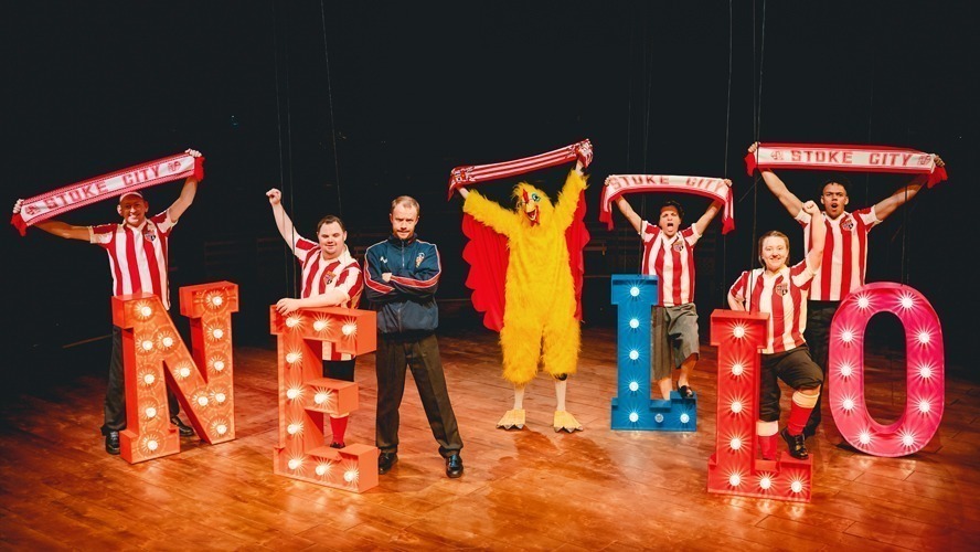 A vibrant stage set with colourful lighting and elaborate decorations, showcasing a theatrical performance.