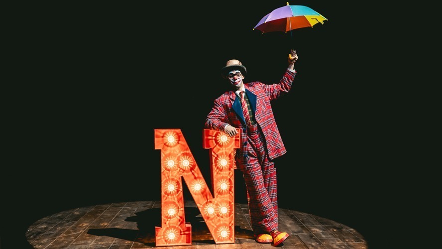 A vibrant stage set with colourful lighting and elaborate props for a theatrical production.