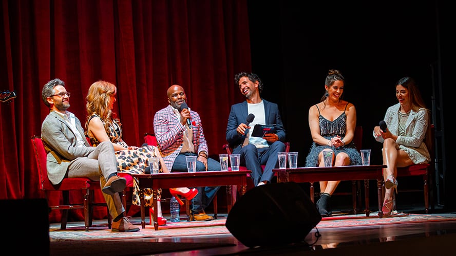 A lively performance scene at the Apollo Theatre, with bright stage lights and an engaged audience.